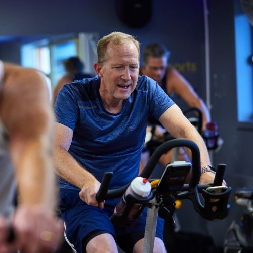 man doing an indoor cycling class