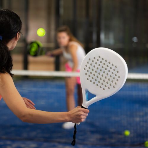 Two women playing padel