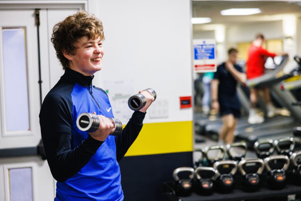 Teenager lifting weights in the gym