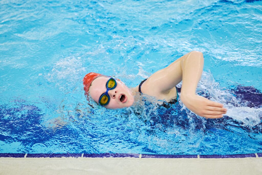 Child doing front crawl in a swimming pool