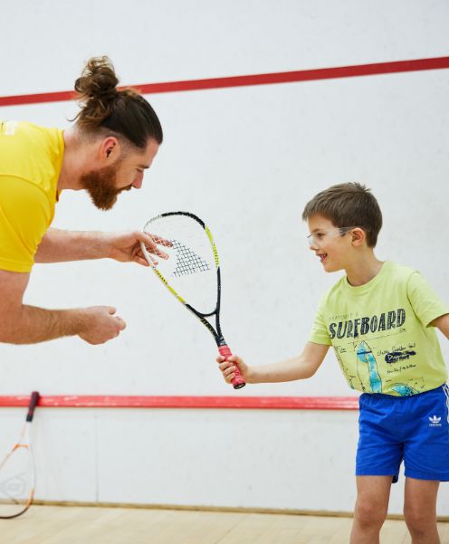 child learning to play squash