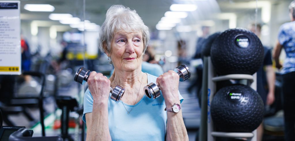 senior lady doing weights in the gym