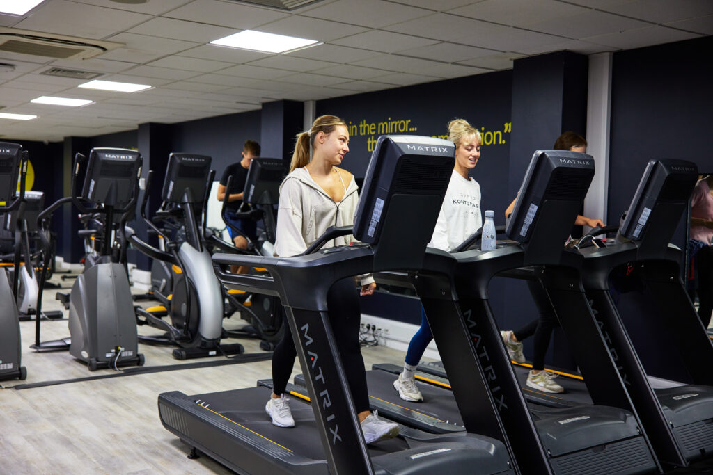 two girls walking and chatting on the treadmill