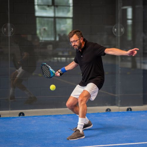 man hitting a padel ball