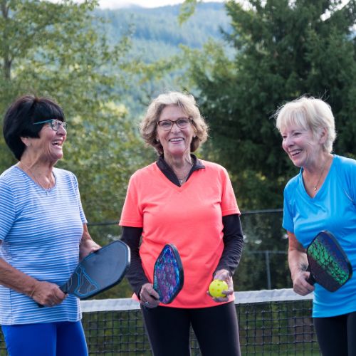 three women playing pickleball