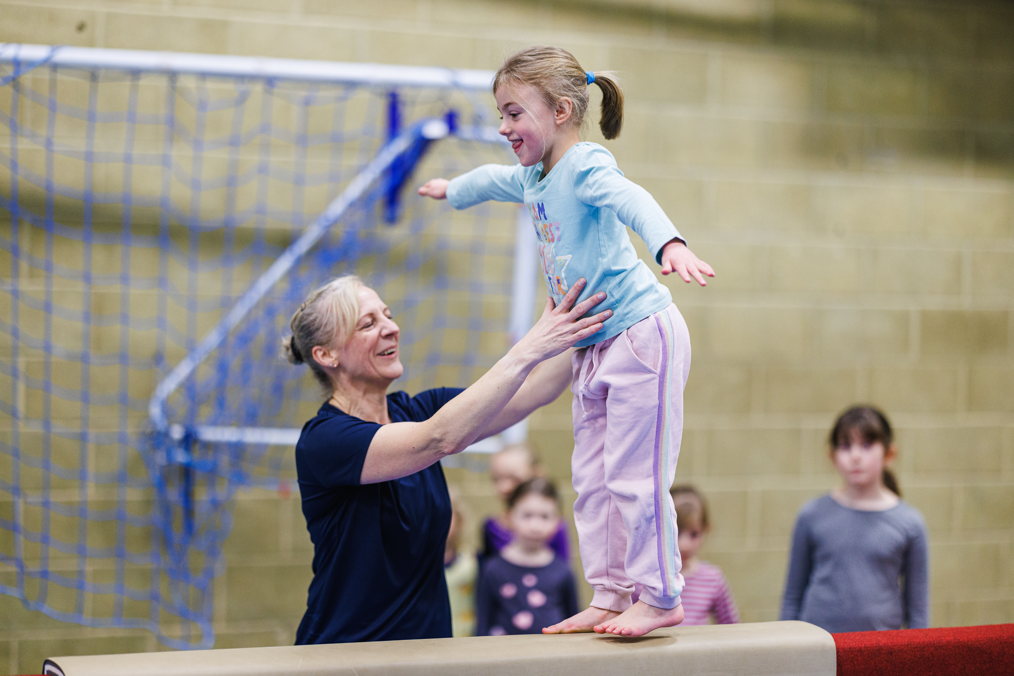 young girl walking on a balance beam