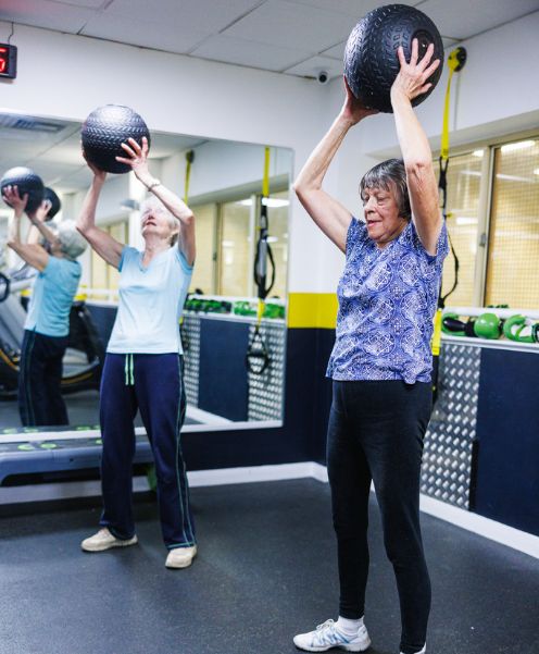 two seniors using slam balls