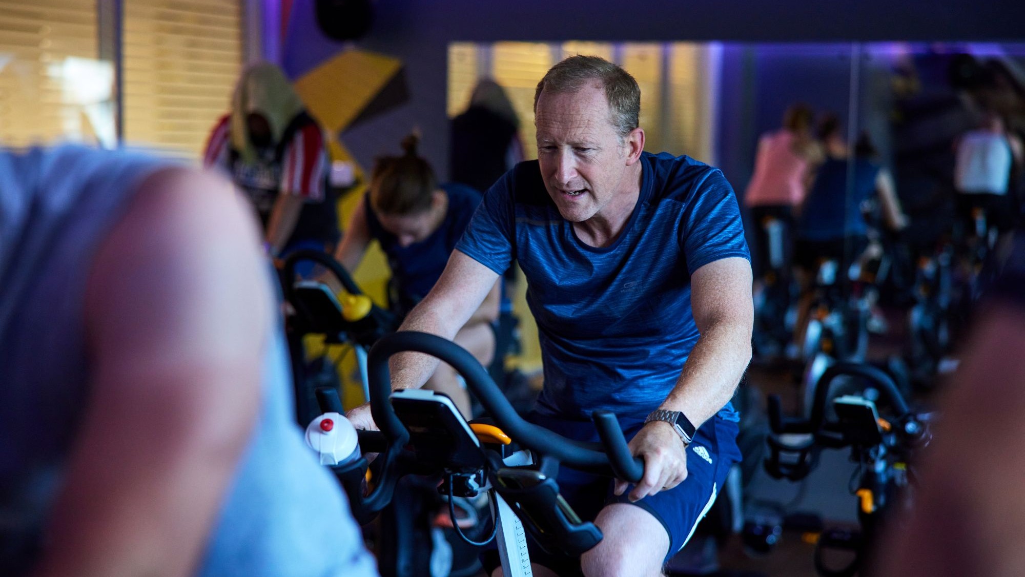 man on bike in indoor cycling class